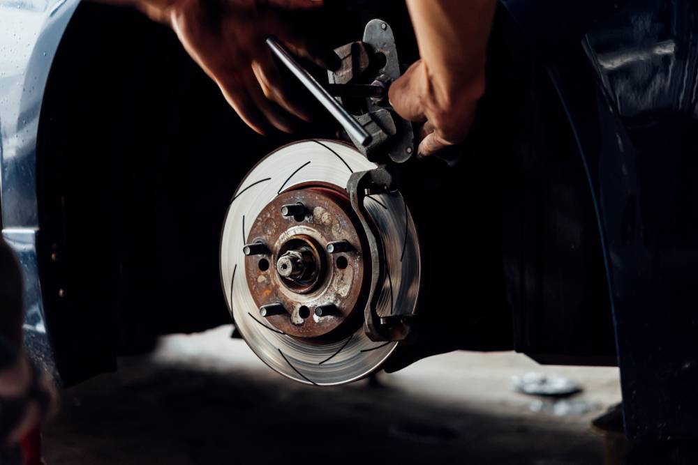 Brake Home Car mechanic or serviceman checking a disc brake and asbestos brake pads it's a part of car use for stop the car for safety at front wheel this a new spare part for repair at car garage